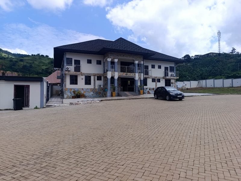 The main building and its paved forecourt, with the drive leading up to the entrance